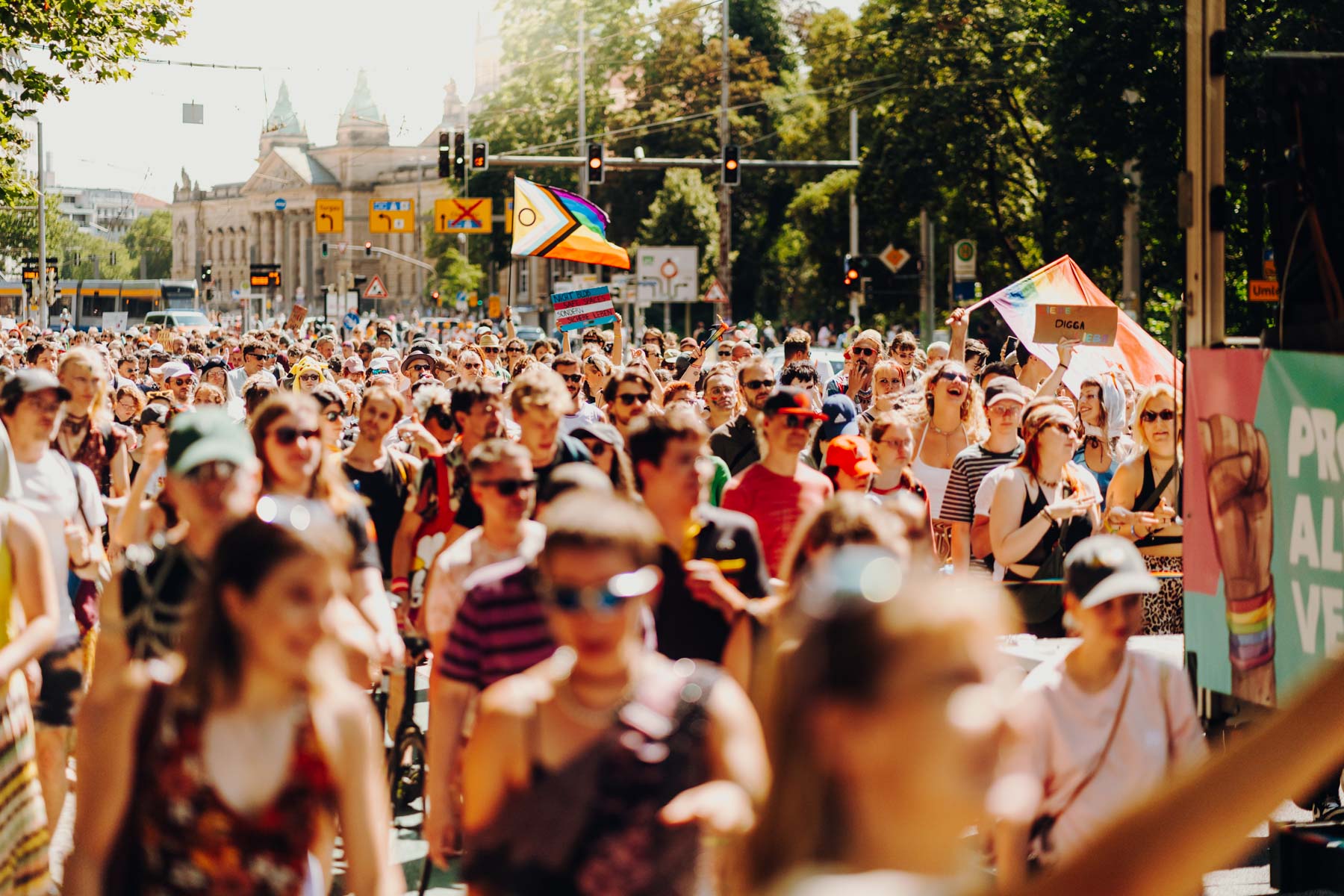 Eventfotograf Leipzig CSD Demo Eine große Menschenmenge zieht mit Regenbogenfahnen beim CSD 2026 durch das sonnige Leipzig